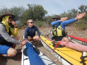 E, Nate, and Matt discussing sails during a training in Baja with Coach Ginni and Sea Kayak Baja